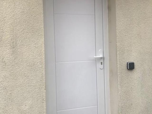 Pose d'une porte d'entrée PVC aux alentours de la loupe 