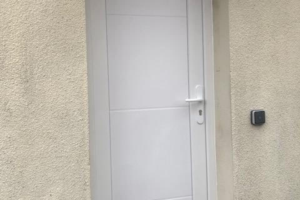 Pose d'une porte d'entrée PVC aux alentours de la loupe 