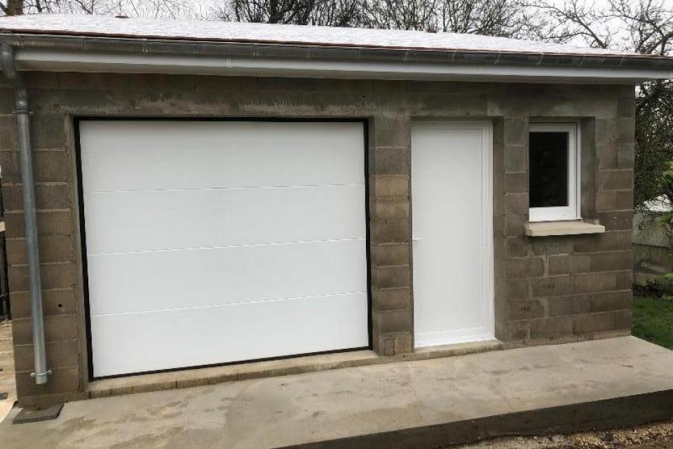 Pose d'une porte de garage, d'une porte de service et d'une fenêtre pour un garage 