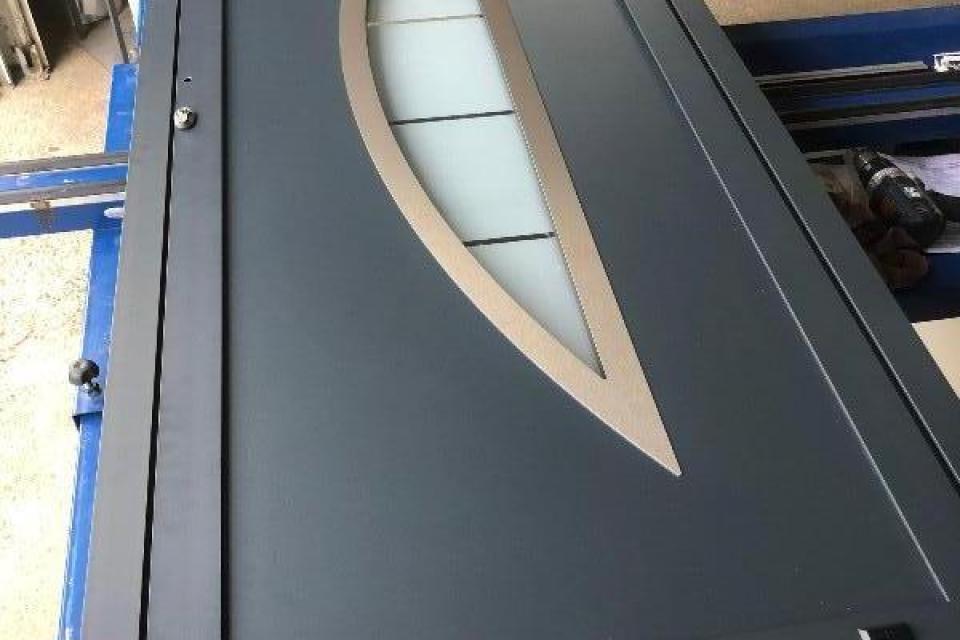 Fabrication d'un porte aluminium avec un vitrage demi-lune installée près de Brou